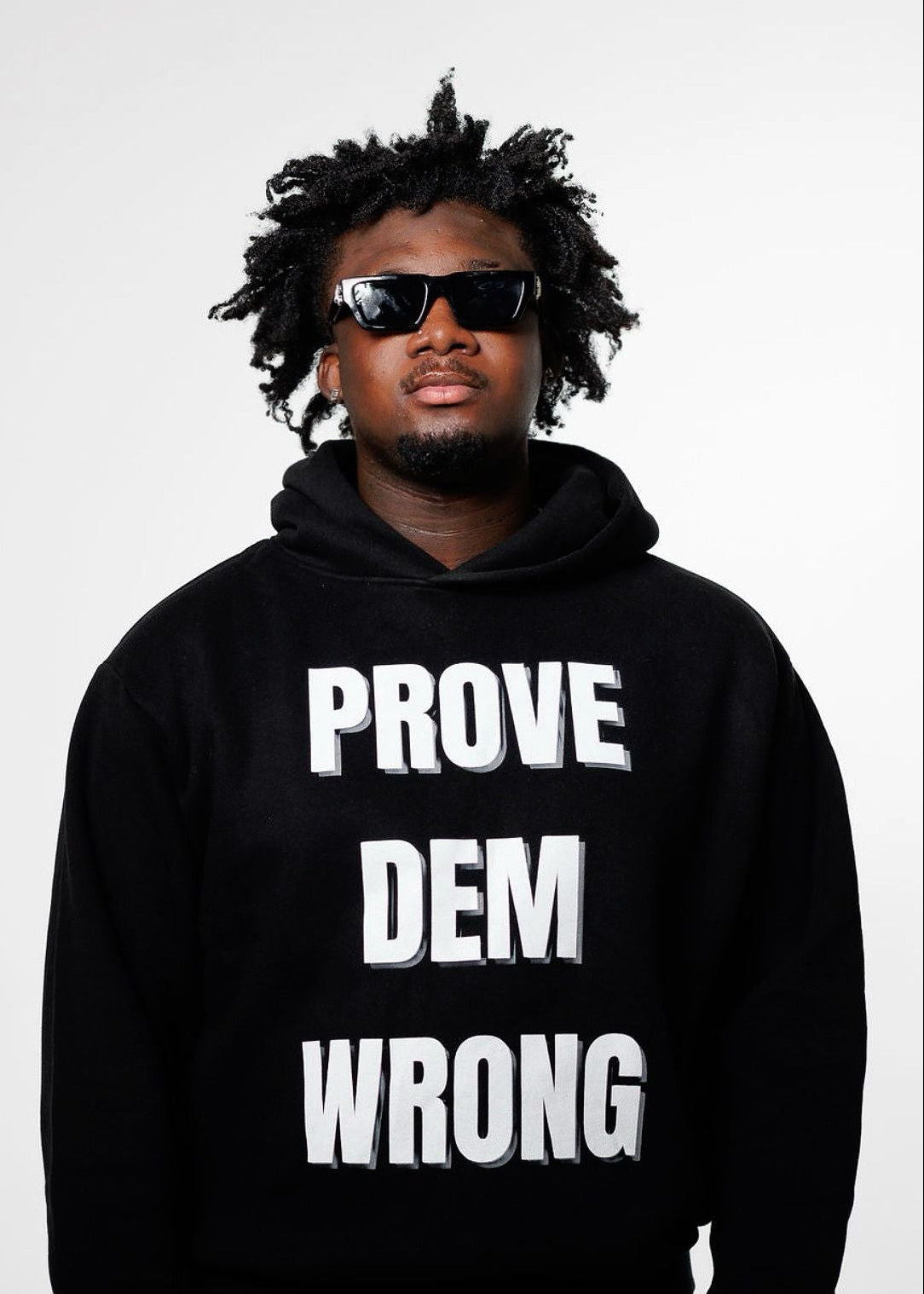 Person wearing a black hoodie with 'PROVE DEM WRONG' text on a white background